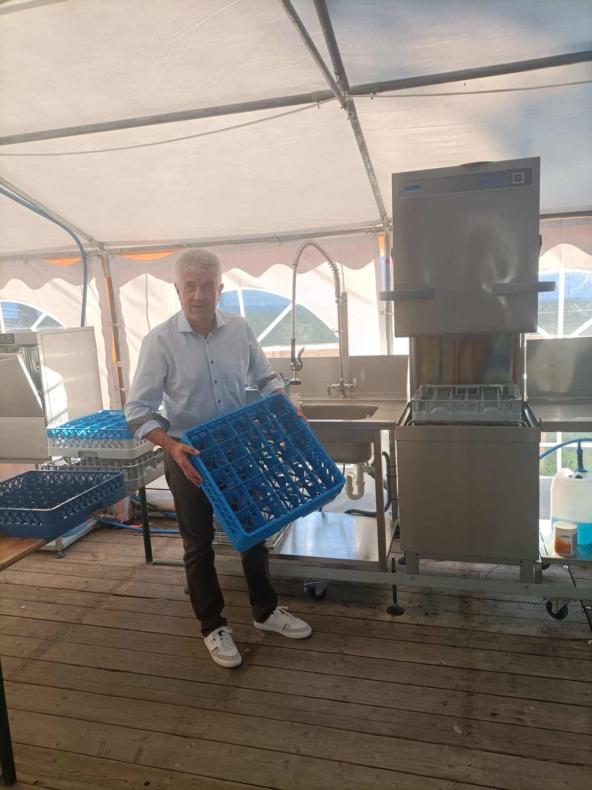 Sepp mit einem Gläserkorb an der Spülmaschine im Festzelt